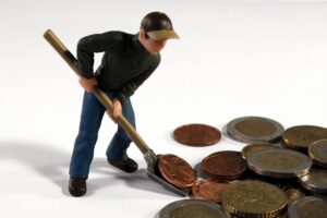 Eine Figur fegt Münzen zusammen