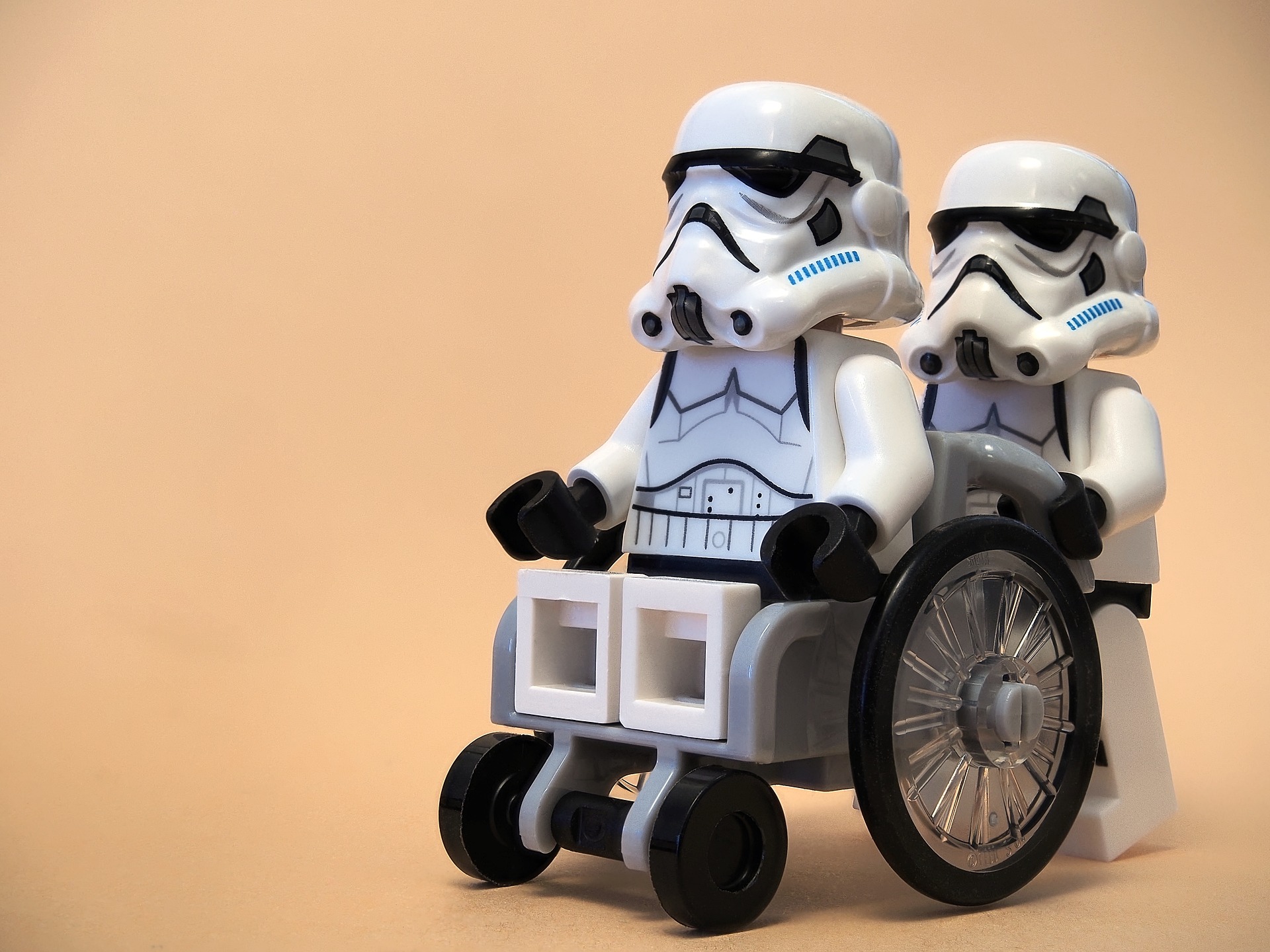 Ein Lego-Stormtrooper sitzt im Lego-Rollstuhl und wird von einem anderen Stormtrooper geschoben