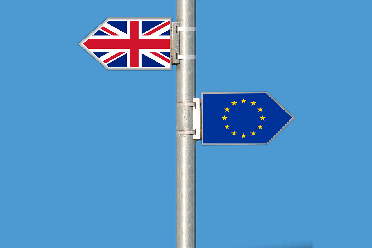 Ein Straßenschild mit zwei Shildern. Eins zeigt Richtung UK das andere Richtung Europa