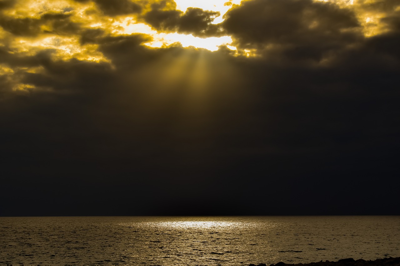 Eine Wolkenlücke über dem Meer durch die Sonnenstrahlen leuchten