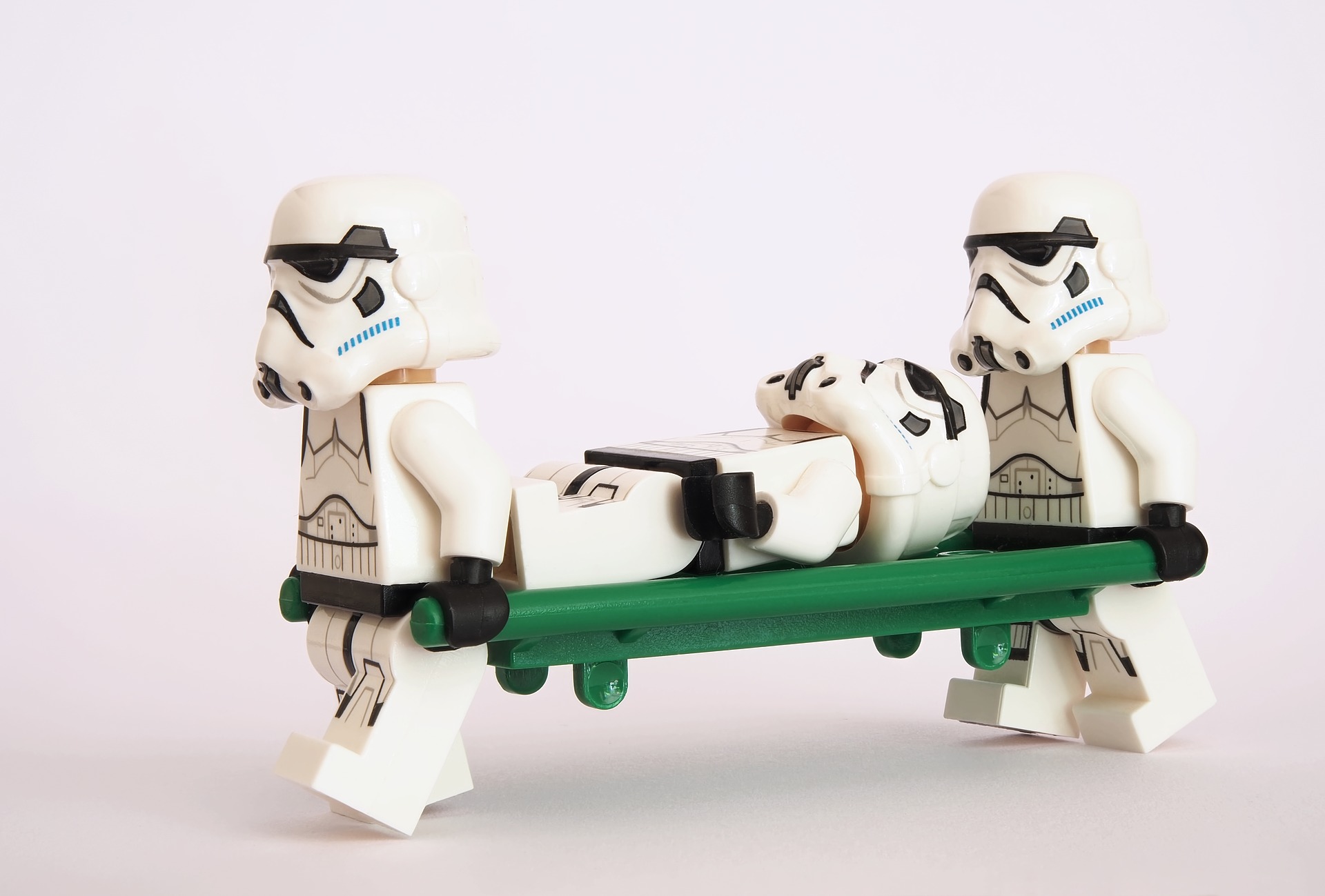 Zwei Lego-Stormtrooper tragen einen verwundeten Stormtrooper auf einer Liege