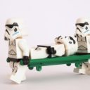 Zwei Lego-Stormtrooper tragen einen verwundeten Stormtrooper auf einer Liege